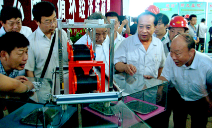 鞍钢矿渣开发公司经理苏兴文与参会代表关注钢渣带磁机演示 鞍钢矿渣开发公司经理苏兴文与参会代表关注钢渣带磁机演示